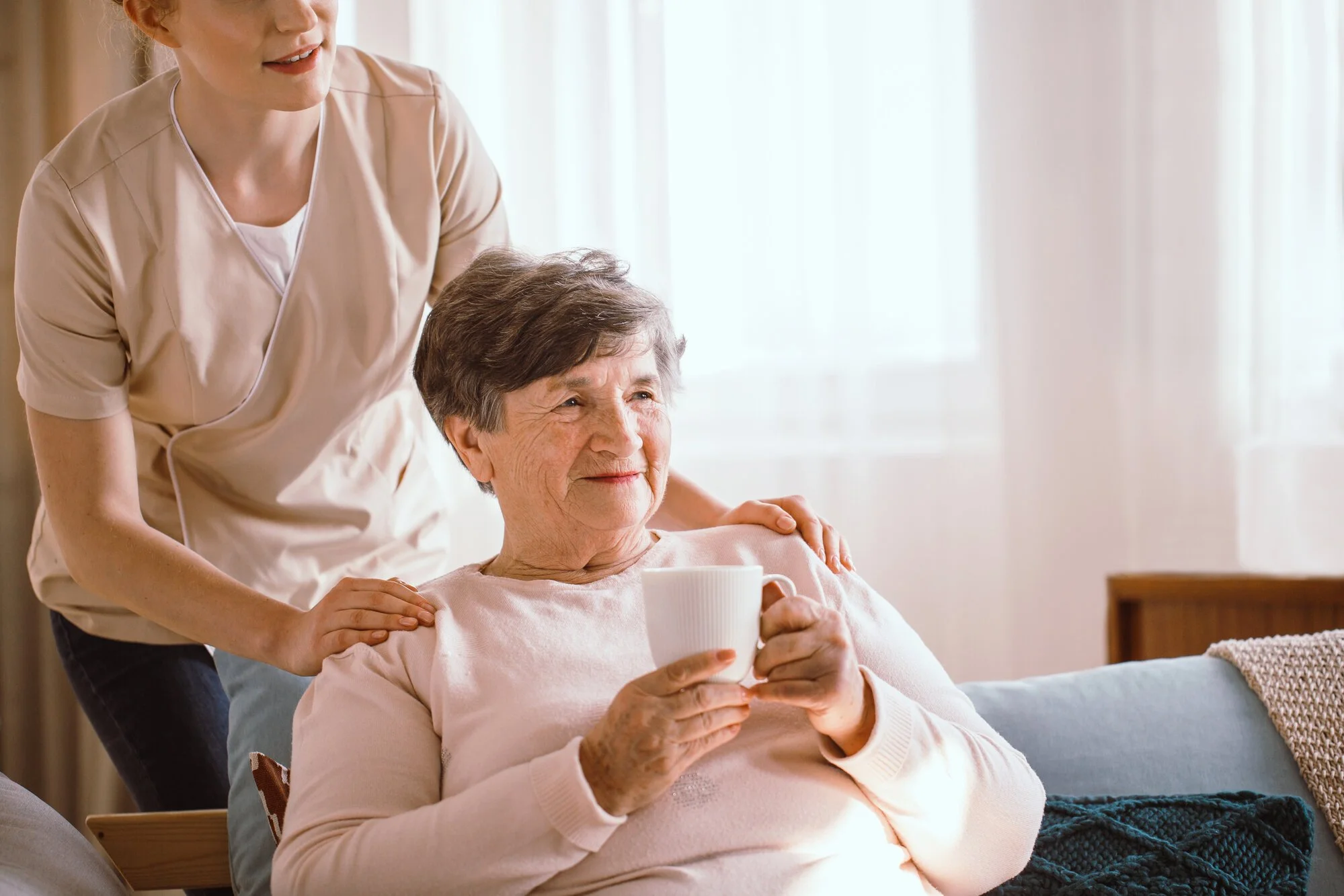 A caregiver offering warm one-to-one support to a senior at home