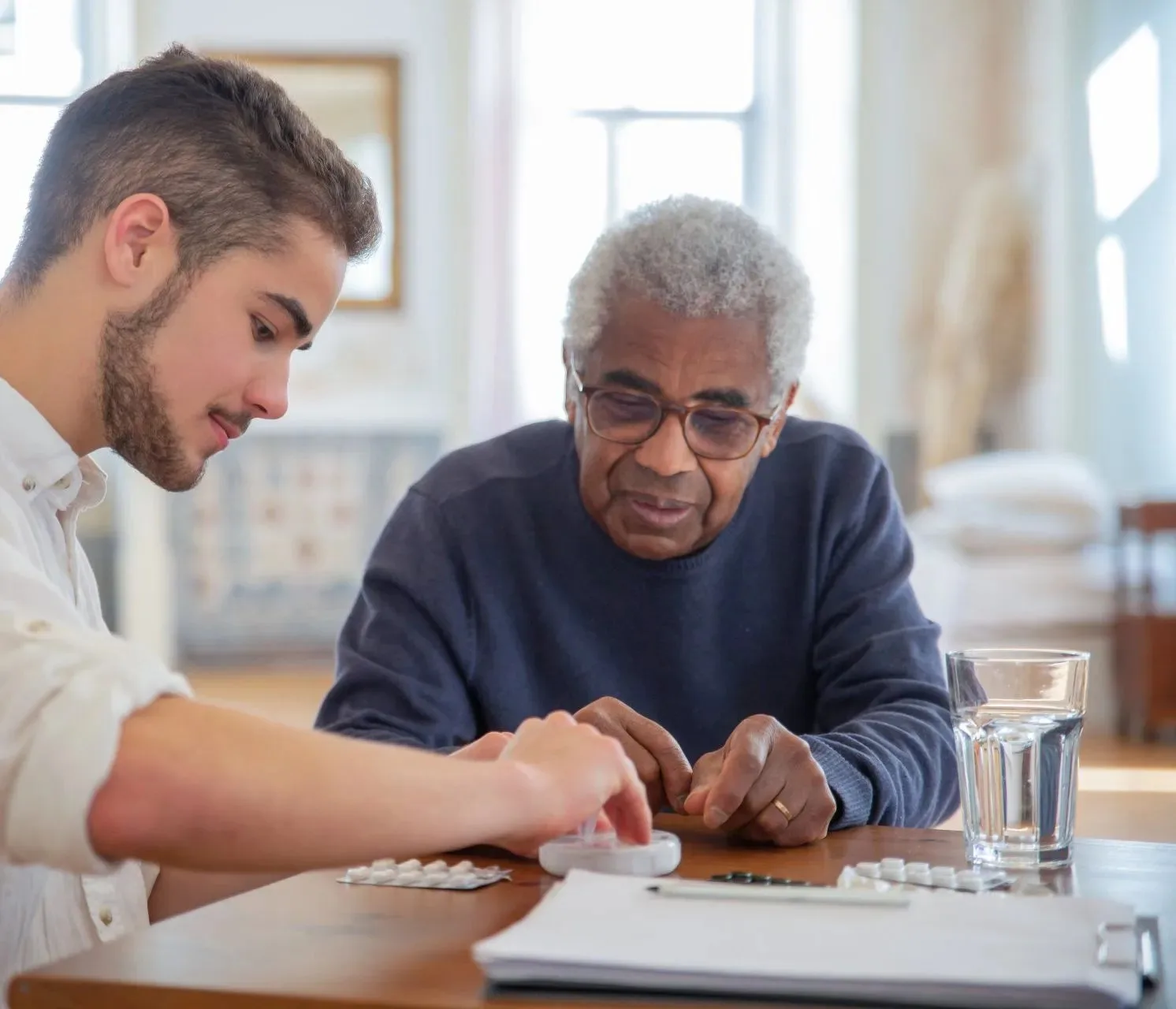 A caregiver providing a gentle medication reminder to a senior